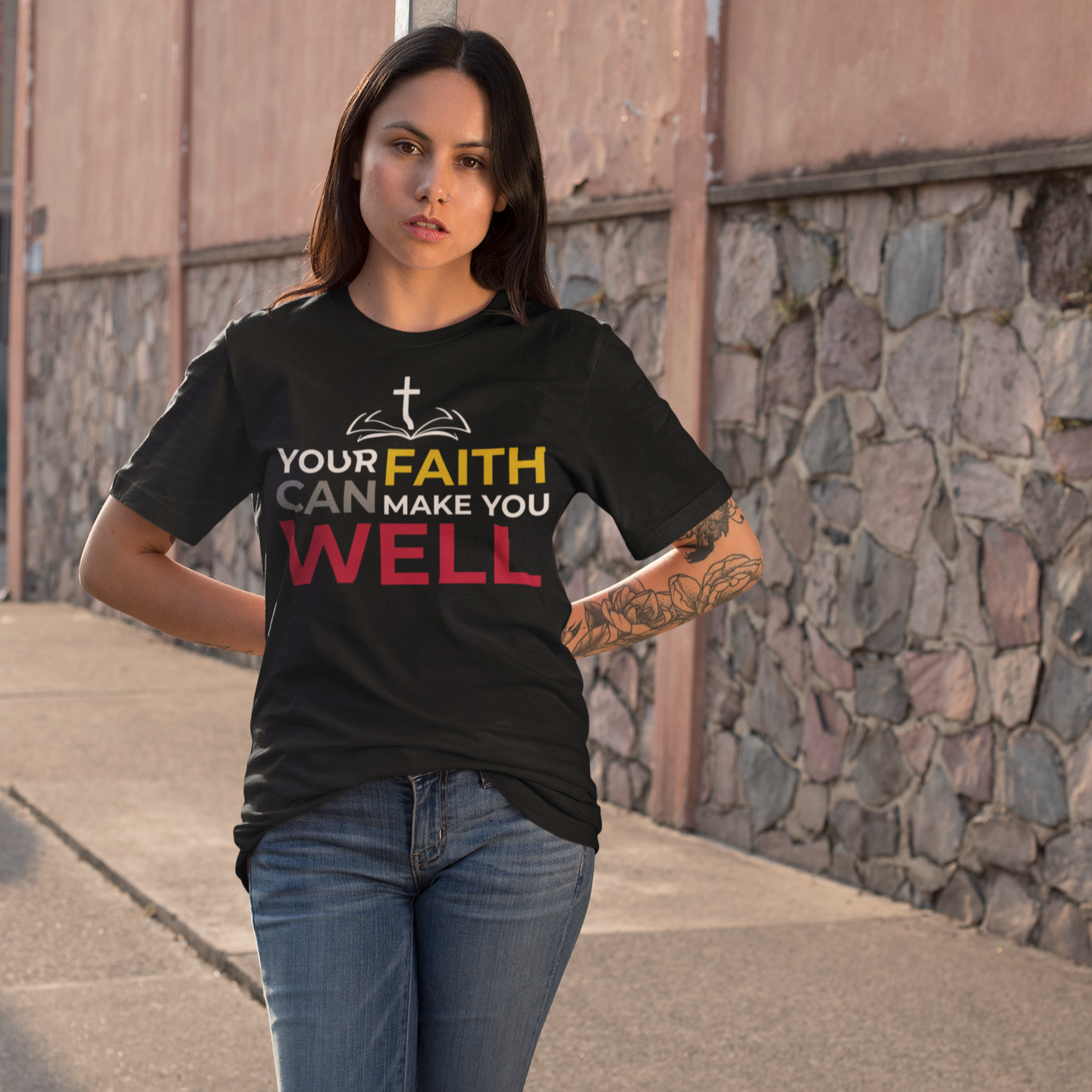 Woman wearing a black t-shirt with a motivational message on a sidewalk.