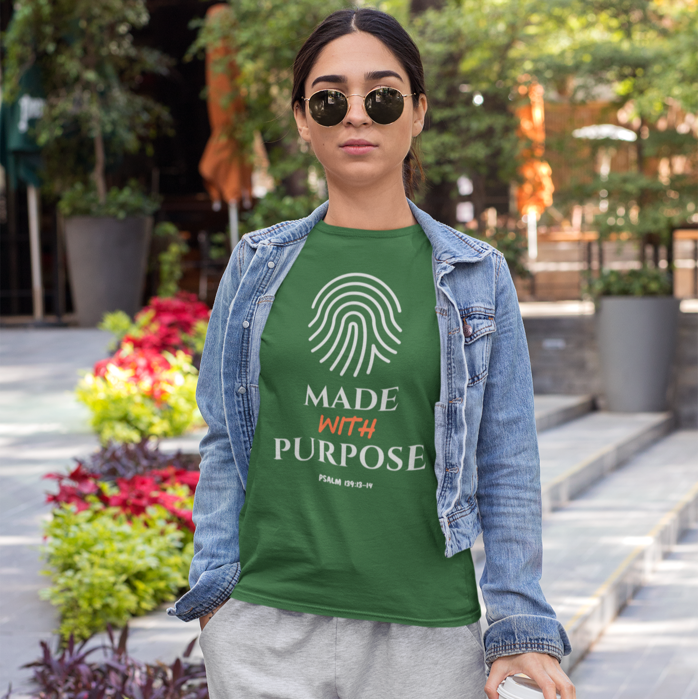 woman wearing a green t-shirt with a fingerprint design and 'Made with Purpose' text