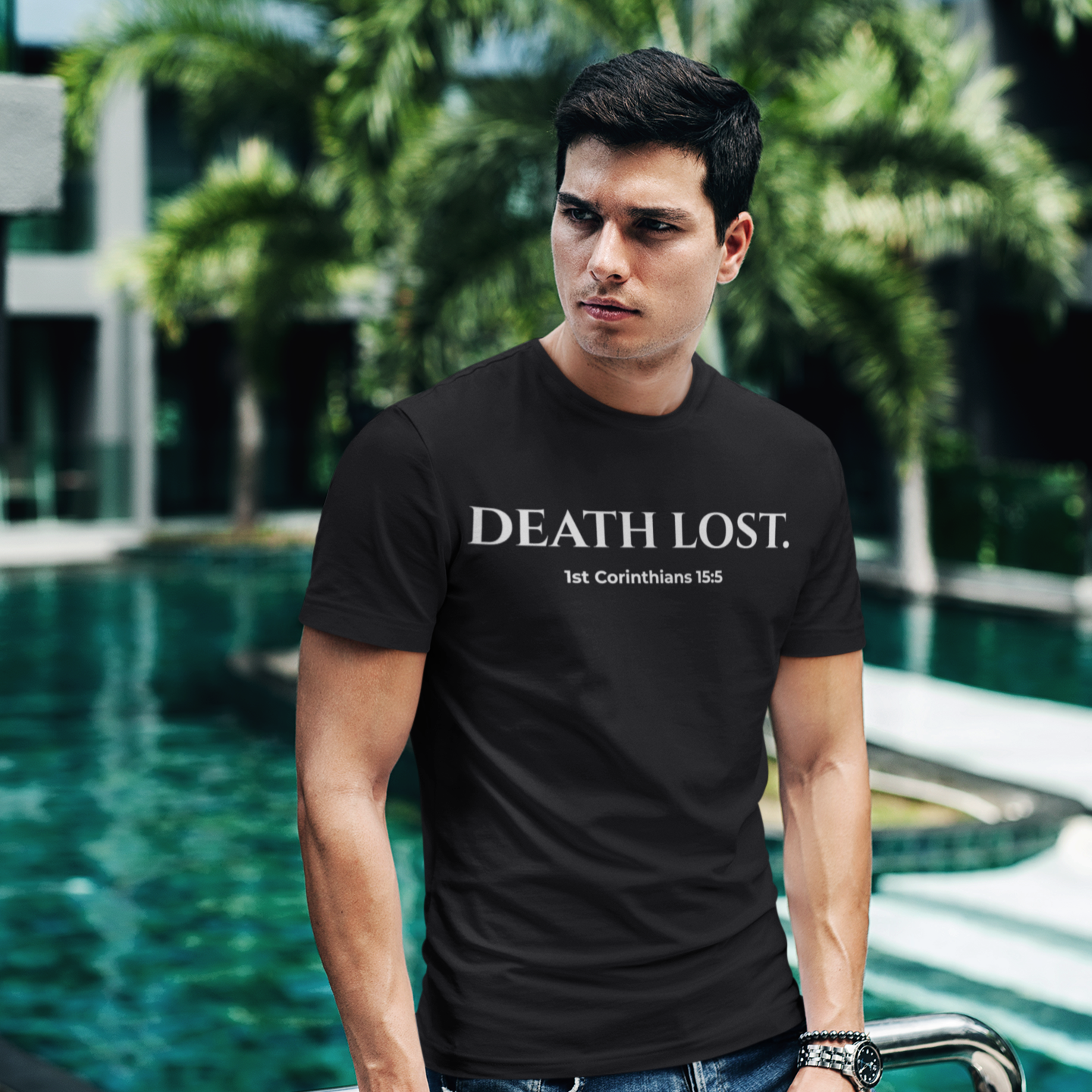 Man wearing a black t-shirt with 'DEATH LOST' text by a poolside.