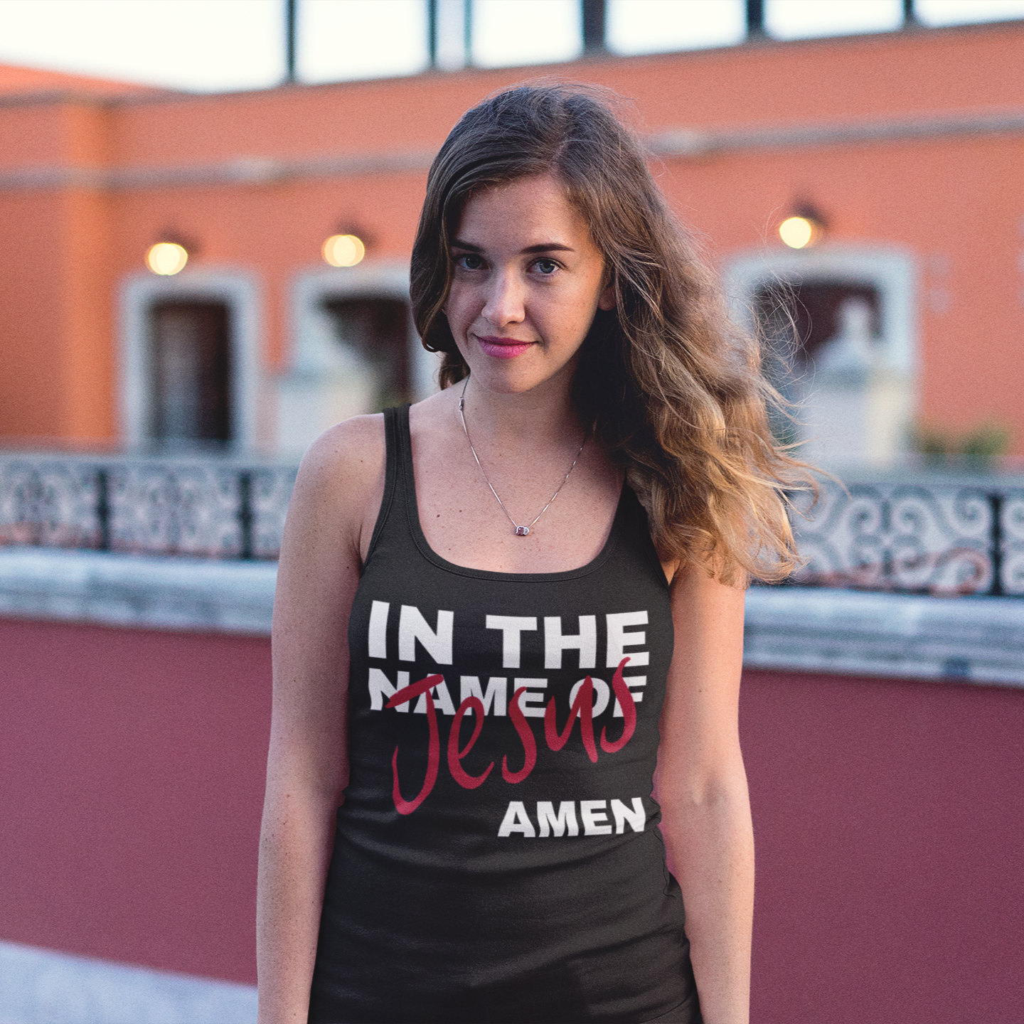 Woman wearing a black tank top with 'In the Name of Jesus Amen' text