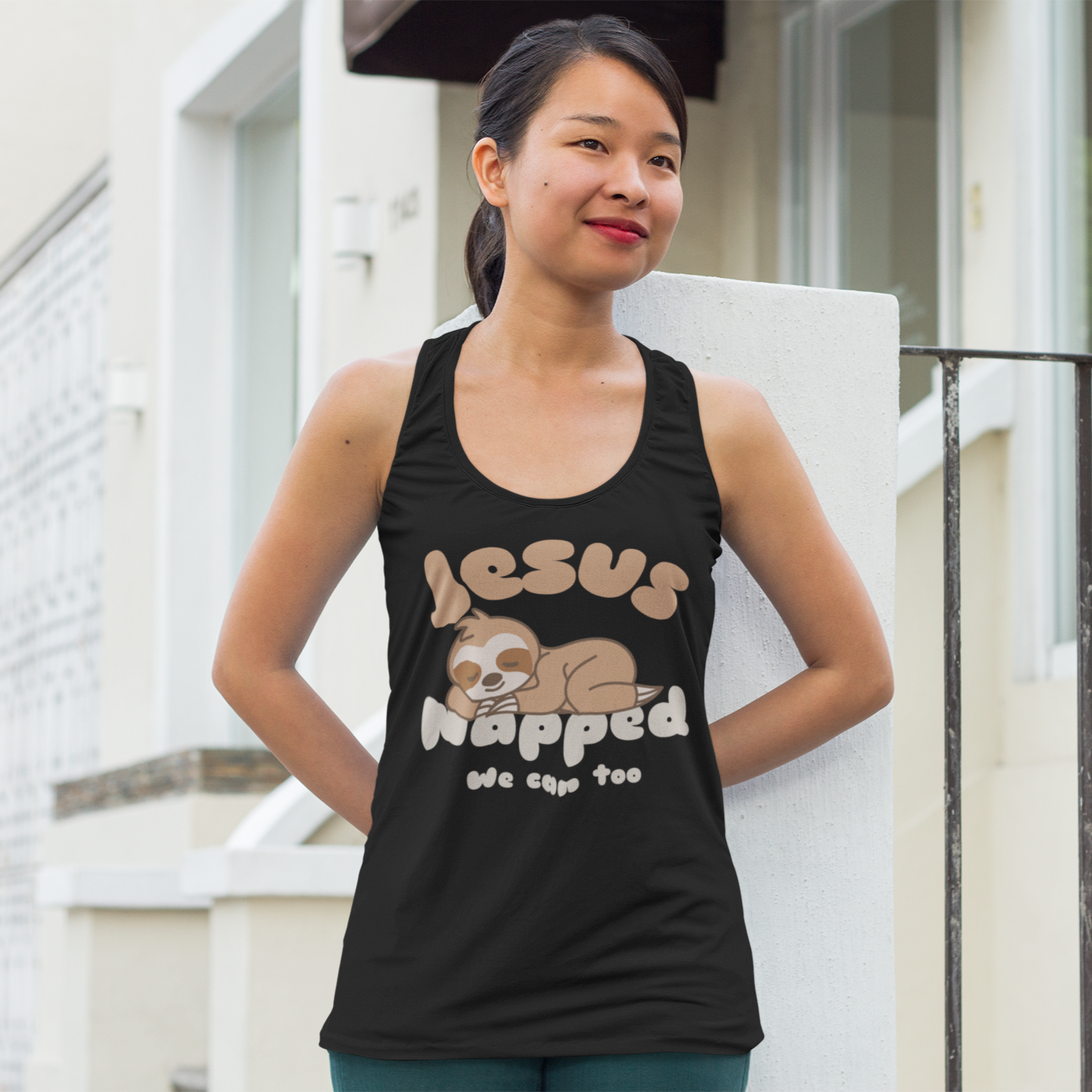 Woman wearing a black tank top with 'Jesus Napped' text and sloth graphic.